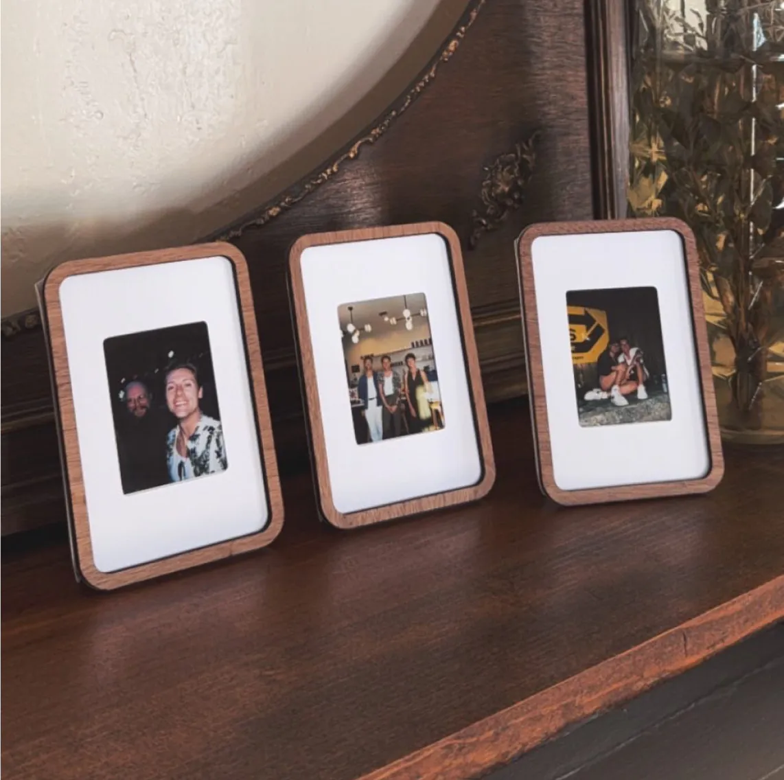 Three Pop-up Frames with photos of friends on a sideboard